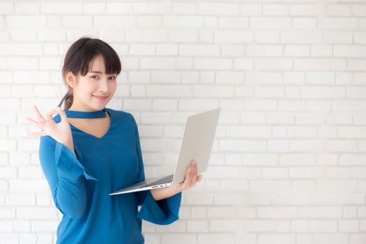 Beautiful freelance young asian woman confident using laptop computer online internet with success, blogger girl expression of excited with achievement from work and having proud in triumph. photo