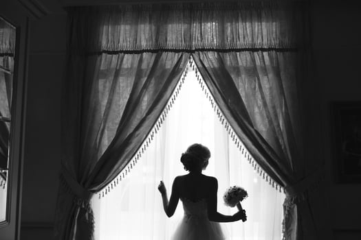 beautiful bride in a wedding dress, by window. photo