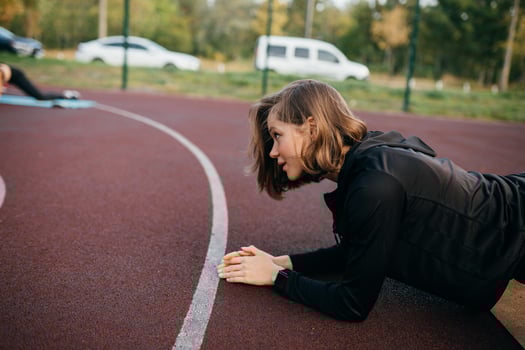 Young fit woman in sportswear trains outdoors on the playground. photo