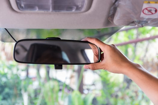Women hand adjusting rear view mirror. photo