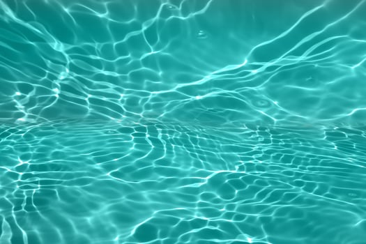 Defocus blurred transparent blue colored clear calm water surface texture with splashes and bubble. Trendy abstract nature background. Water wave in sunlight with copy space. Blue watercolor texture photo