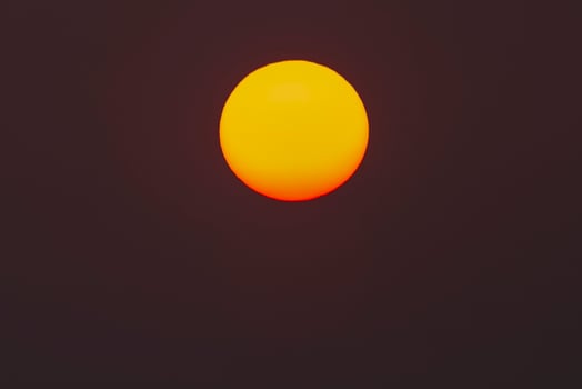 The evening or morning sun can be seen with the naked eye. The sun is red because of the dust and atmosphere. photo