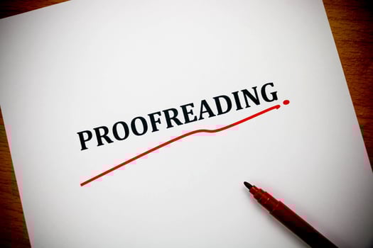 proofreading word on white sheet with red pen photo
