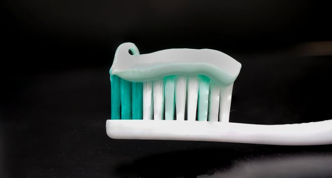 toothbrush and toothpaste on black background photo