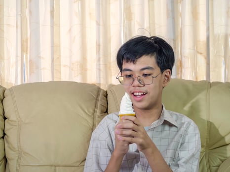 Asia boy kid hold vanilla ice cream in waffles cone happy smiling and eating deliciously in summer with have fun and good mood. photo