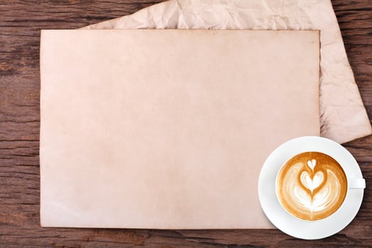 blank paper with pencil and a cup of coffee on wooden photo