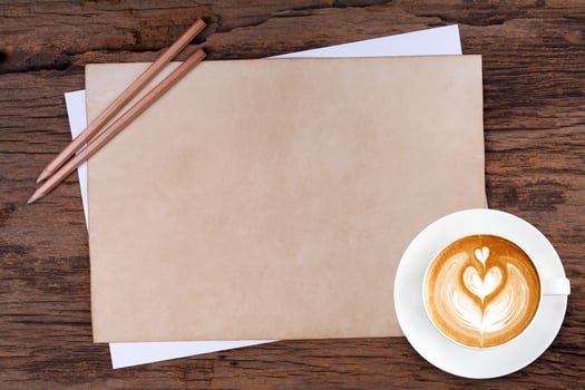 blank paper with pencil and a cup of coffee on wooden photo