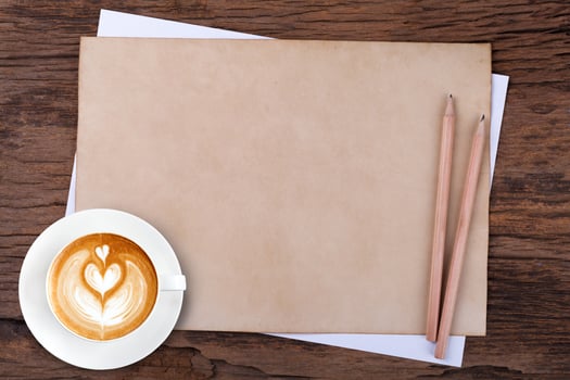 blank paper with pencil and a cup of coffee on wooden photo
