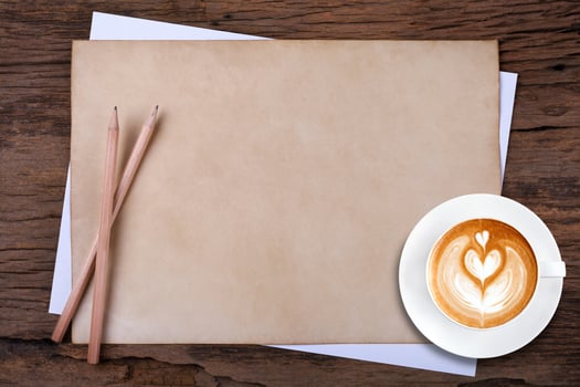 blank paper with pencil and a cup of coffee on wooden photo