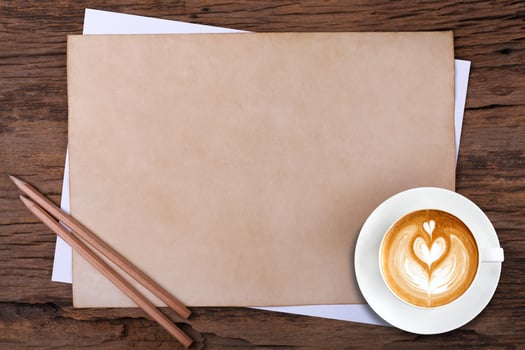 blank paper with pencil and a cup of coffee on wooden photo