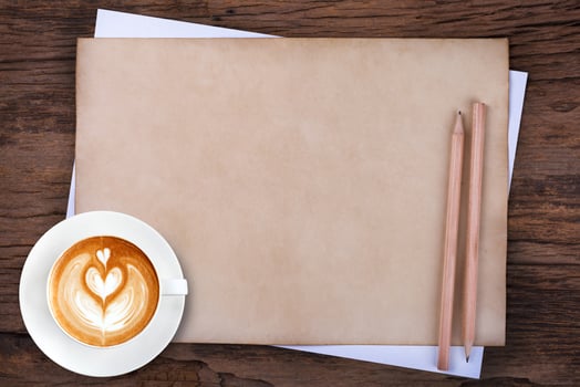 blank paper with pencil and a cup of coffee on wooden photo
