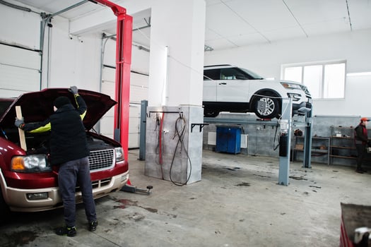 Two american SUV car on stand for wheels alignment camber check in workshop of service station. photo