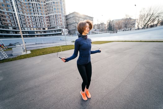 Young woman exercise with skipping rope outdoors photo
