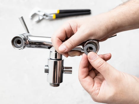 hands install paronite gasket in faucet and wrench photo