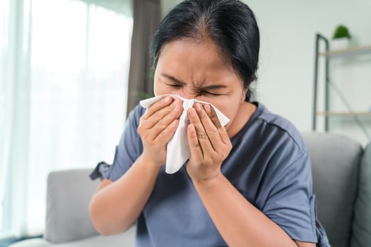 Cold sick woman got nose allergy cough or sneeze with tissue paper sitting on the sofa. Healthcare and medical concept. photo