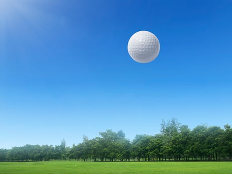 Golf ball floating in the air on a golf course photo