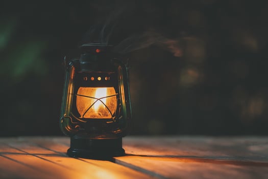 antique kerosene lamp with lights on the wooden floor at night photo