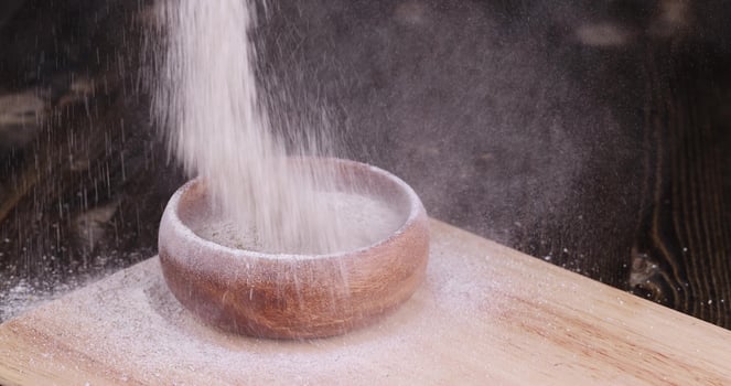 pour wheat flour with bran into a wooden plate photo