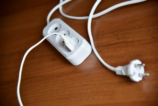 White electric extension cord on a wooden background photo