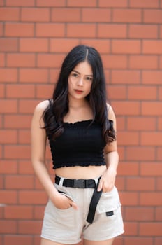 Portrait of hipster girl  on brick wall background,Beautiful asian woman pose for take a photo,Kawaii style photo