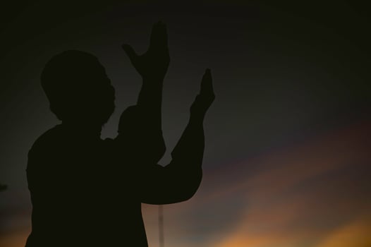 Silhouette Young asian muslim man praying on sunset,Ramadan festival concept photo