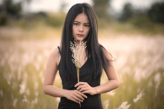 Portrait of beautiful asian woman at grass field on sunset photo