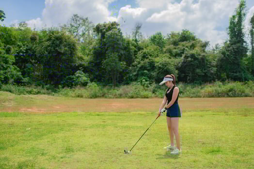 Portrait of golfer asian woman holding golf wood at the country club,Happy woman concept,Put golf on pin photo