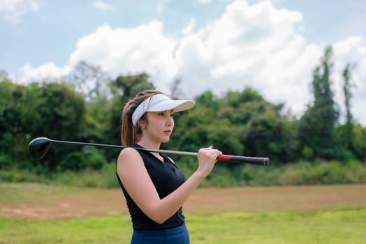 Portrait of golfer asian woman holding golf wood at the country club,Happy woman concept,Put golf on pin photo
