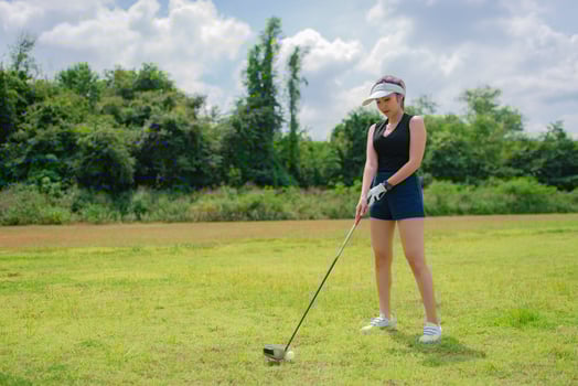 Portrait of golfer asian woman holding golf wood at the country club,Happy woman concept,Put golf on pin photo
