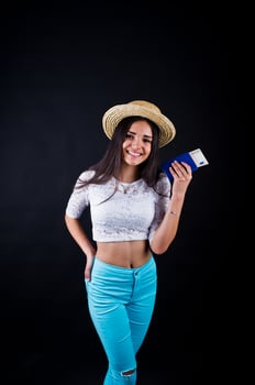 Portrait of a happy woman posing with passport and hat. photo