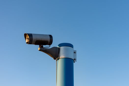Security camera in front of blue sky photo