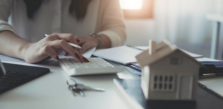 Buying and selling houses and real estate prices concept. woman using calculator to count rent, money or home insurance cost. Calculating mortgage, loan or investment. photo