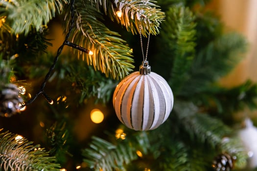 Classic Christmas decorated New year tree. Christmas tree with wite and silver decorations, ornaments toy and ball. Modern classical style interior design apartment. Christmas eve at home. photo