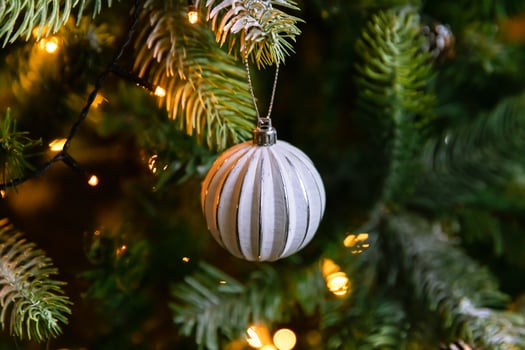 Classic Christmas decorated New year tree. Christmas tree with wite and silver decorations, ornaments toy and ball. Modern classical style interior design apartment. Christmas eve at home. photo