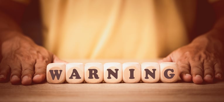 wooden blocks placed in front of the man and the message warning, the concept of prevention of danger and safety from crime and threats,Notice in advance to prevent danger and be careful. photo