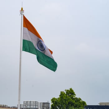 India flag flying high at Connaught Place with pride in blue sky, India flag fluttering, Indian Flag on Independence Day and Republic Day of India, tilt up shot, Waving Indian flag, Har Ghar Tiranga photo