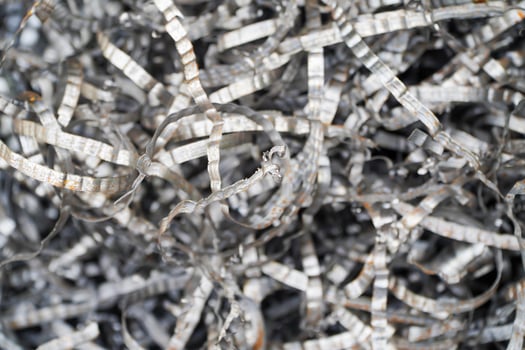 Steel scrap materials recycling. Aluminum chip waste after machining metal parts on a cnc lathe. Closeup twisted spiral steel shavings. Small roughness sharpness, photo