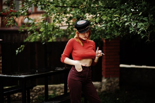 Fashion portrait of redhaired sexy girl outdoor. Model attractive seduction woman with cigarette. photo