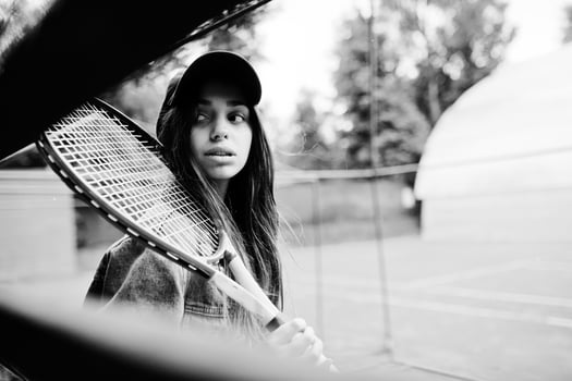 Young sporty girl player with tennis racket on tennis court. photo