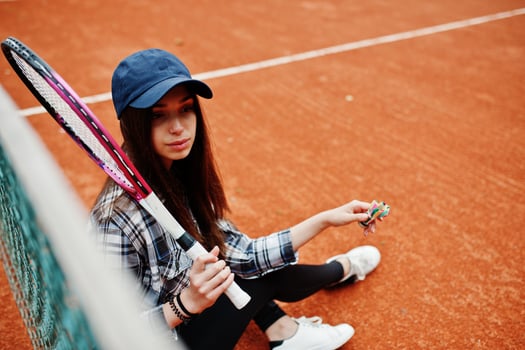 Young sporty girl player with tennis racket on tennis court. photo