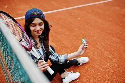 Young sporty girl player with tennis racket on tennis court. photo