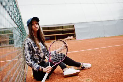 Young sporty girl player with tennis racket on tennis court. photo