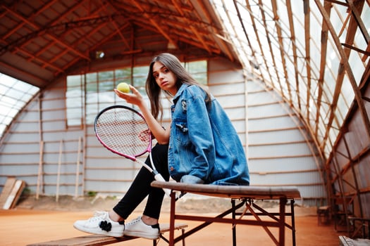 Young sporty girl player with tennis racket on tennis court. photo