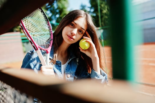 Young sporty girl player with tennis racket on tennis court. photo