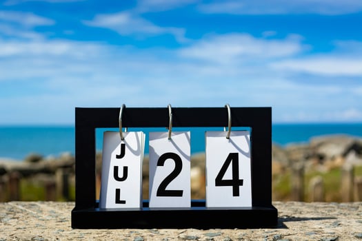 Jul 24 calendar date text on wooden frame with blurred background of ocean. photo
