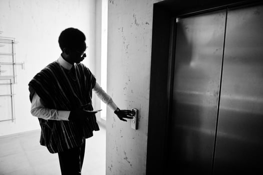African american man at elavator or modern lift, pushing button. photo