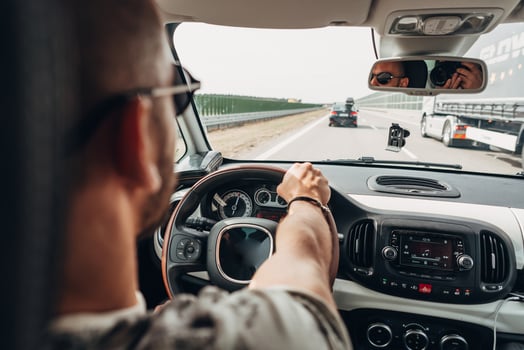 The man in the car traveling on the road photo
