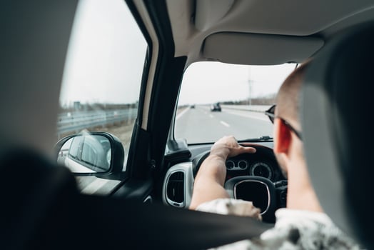 The man in the car traveling on the road photo