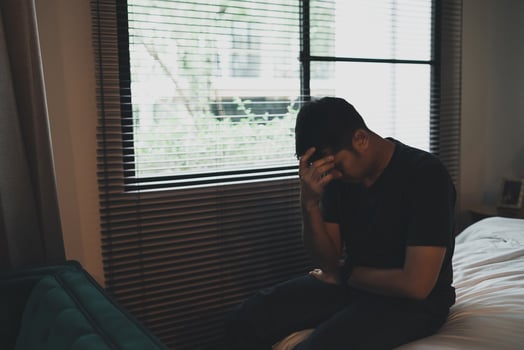 Sad asian man suffering depression insomnia awake and sit alone on the bed in bedroom. Silhouette depressed man sadly sitting on the bed in the bedroom, depression concept photo