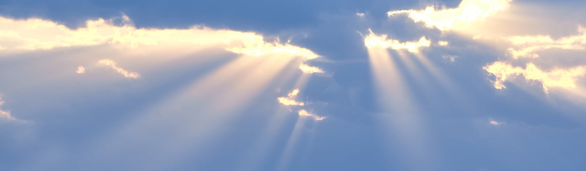 The sun's rays break through the blue clouds. The background of the sky. photo